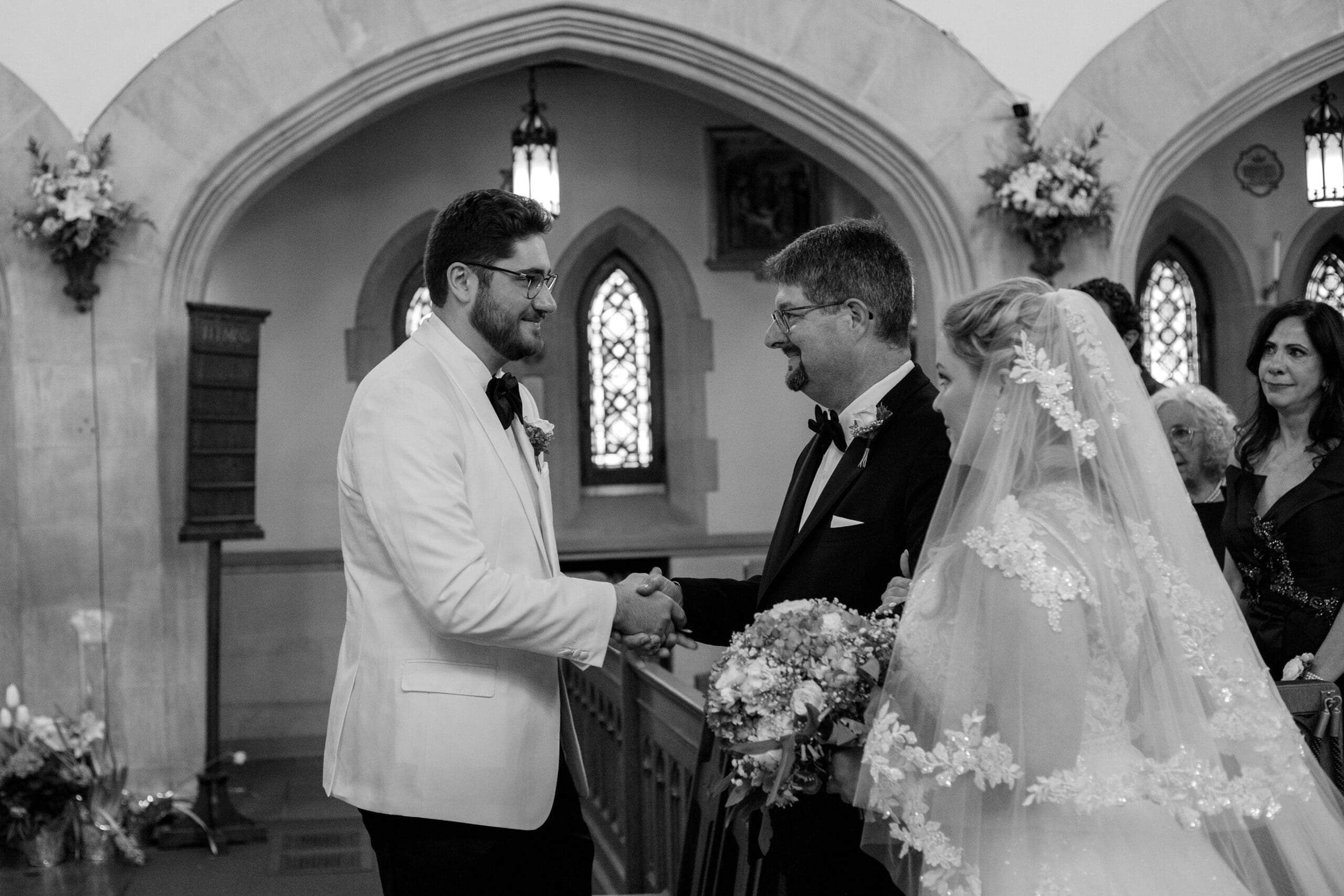 Father of the bride hands off bride to groom during traditional Latin Mass wedding ceremony 