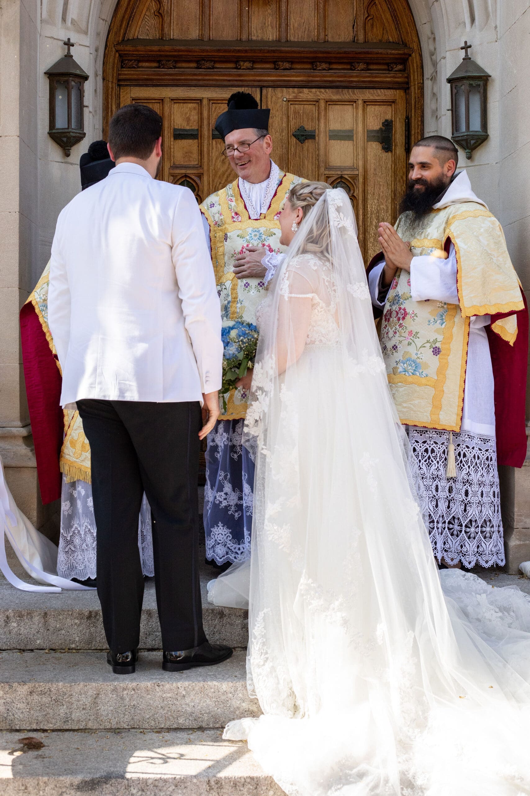 Bride and groom thanking their priest for celebrating their wedding nuptials 