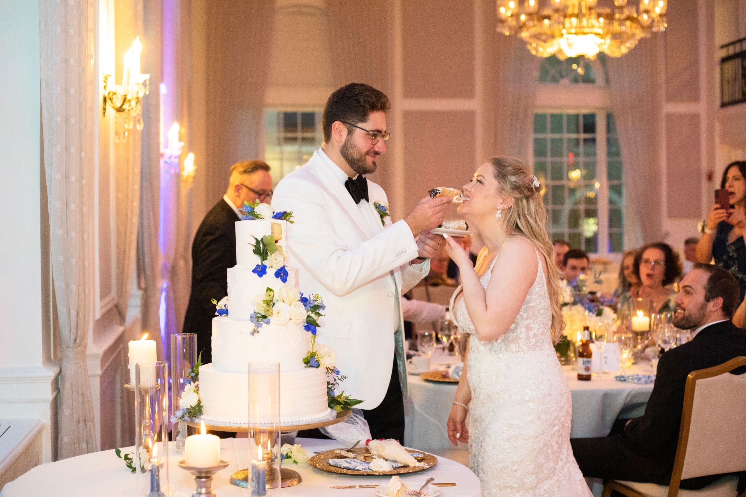Bride and groom splitting a wedding dessert at their wedding reception 