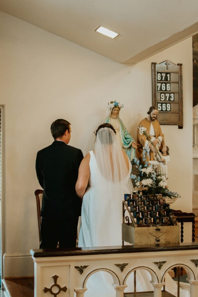 Husband and wife venerate the Blessed Mother at their Catholic wedding Mass